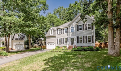 View of front of home featuring driveway, a chimney, and roof with shingles