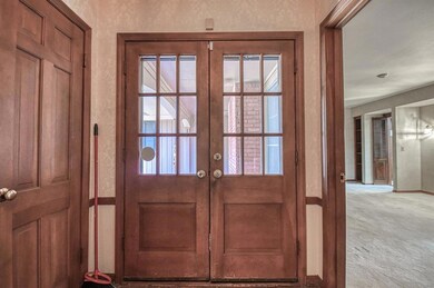 Entryway with french doors and light carpet