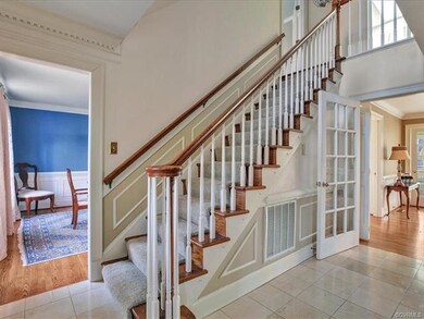 Gorgeous foyer with detailed molding and new carpe