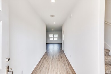 Hall with light wood finished floors, recessed li