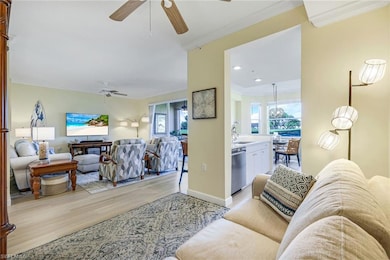 Living room featuring crown molding, baseboards, ceiling fan, recessed lighting, and light wood-type flooring