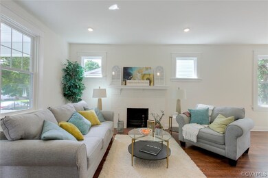 Open and Bright Living Room with Refinished Hardwood Floors, Brick Fireplace, Recessed Lighting and open to Dining Room