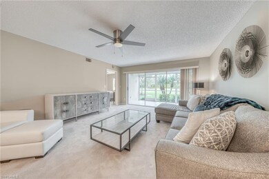 Living room featuring ceiling fan, light carpet, a