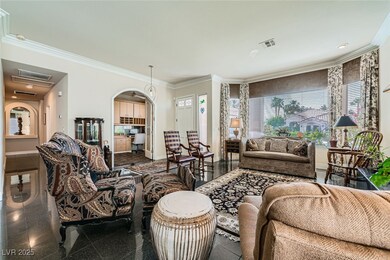 Living area featuring crown molding, arched walkways, baseboards, and granite floors