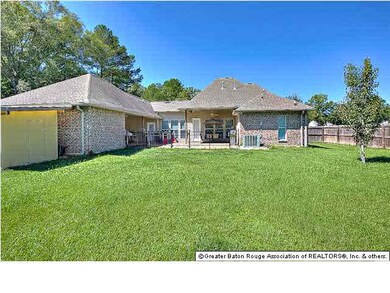 Fully fenced back yard has a double gate providing