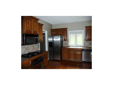 Kitchen has hardwood floors and stainless steel ap