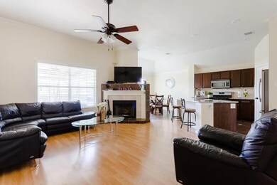 Living area featuring a ceiling fan, light wood-s