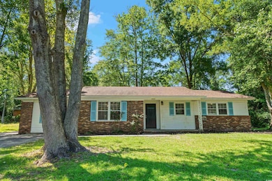 Single story home with a front yard, brick siding, and asphalt driveway