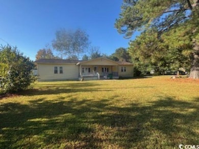 Back of house featuring a yard and a porch