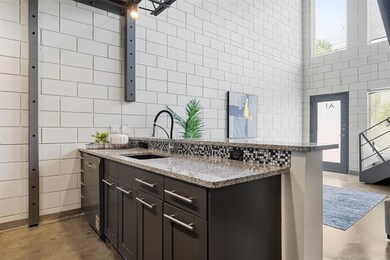 Kitchen featuring concrete flooring, a sink, stai