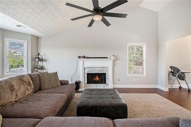 Living area with lofted ceiling, baseboards, dark 