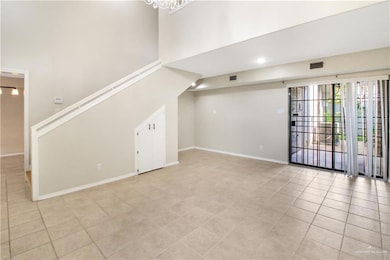 Unfurnished living room with light tile patterned floors, a high ceiling, and stairway