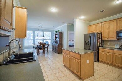 Kitchen with a sink, visible vents, crown molding