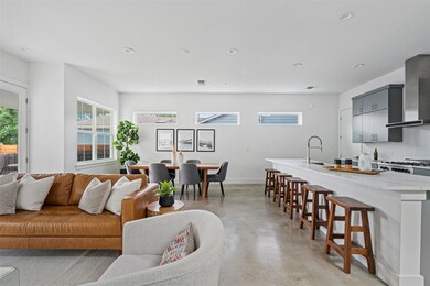 Living area featuring concrete flooring, baseboar