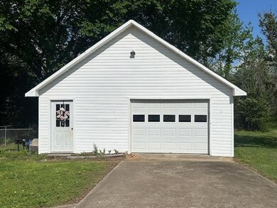 Detached garage featuring driveway and fence