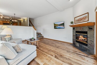 Living area featuring a tiled fireplace, light woo