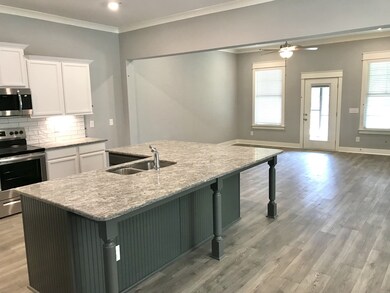 Stock photo showing view of large island and great room. Large granite counter tops to seat a huge party. That's island life!