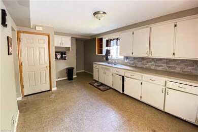 Kitchen featuring light tile flooring, backsplash,