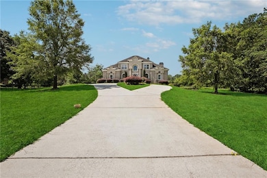View of front of house featuring curved driveway, a front lawn, and a chimney