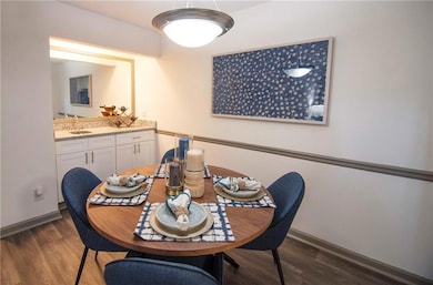 Dining space featuring dark wood-type flooring and sink