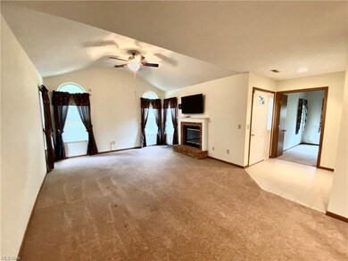 Great room with cathedral ceiling, gas fireplace, and television just off the foyer.