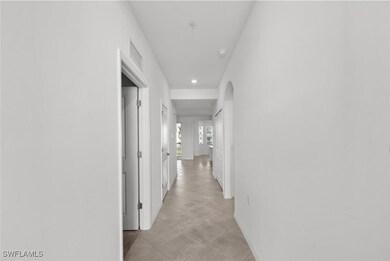 Corridor with visible vents, arched walkways, and baseboards