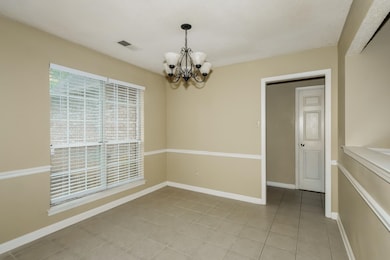 Spare room with a chandelier and light tile patterned floors