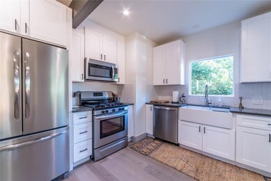 Kitchen with white cabinets, dark countertops, ap
