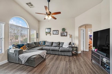 Open spacious great room with vaulted ceilings and ceiling fan.