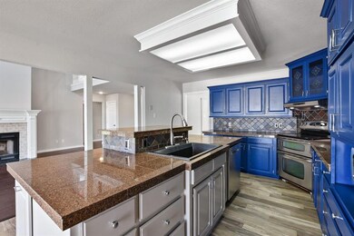Oversized island plus bright cabinets that add a pop of color to this grand kitchen.
