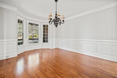 Unfurnished dining area with visible vents, ornamental molding, a chandelier, wood finished floors, and a wainscoted wall