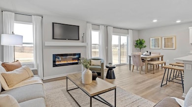 Bright living room with two windows for natural light, dining room with patio doors. Model home, finishes will vary.