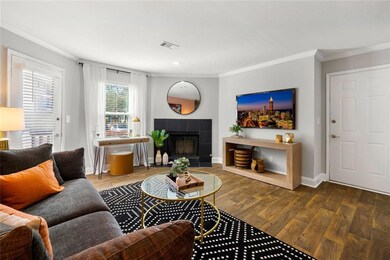 Living room with crown molding, hardwood / wood-style flooring, and a fireplace