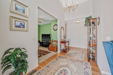 Foyer with wood finished floors and a chandelier