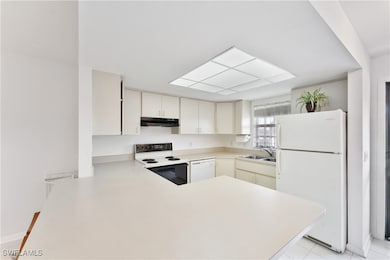 Kitchen with kitchen peninsula, sink, and white ap