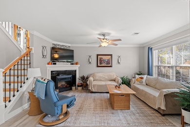 Living room featuring crown molding, ceiling fan, 