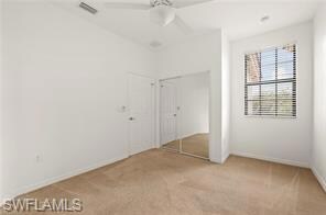 Unfurnished bedroom featuring light colored carpet, ceiling fan, and a closet