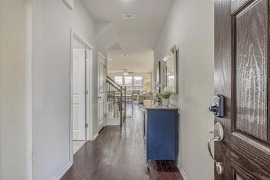 Hall featuring a textured wall, dark wood-style f