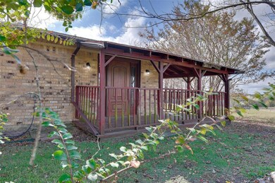 This covered patio is the private entrance to the primary bedroom.  Mature trees offer plenty of shade and seasonal color to enjoy.