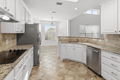 Kitchen with backsplash, white cabinetry, and recessed lighting
