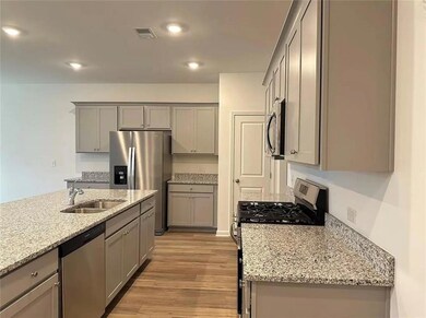 Kitchen with light wood-type flooring, gray cabine