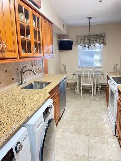 Kitchen with a sink, stove, stainless steel dishwasher, brown cabinetry, and decorative backsplash