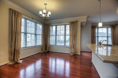 Unfurnished dining area with a sink, a chandelier, crown molding, dark wood-style floors, and baseboards