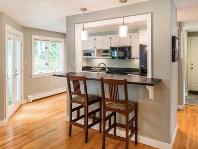 The kitchen has white cabinets set...