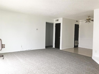 Carpeted spare room featuring ceiling fan and a textured ceiling