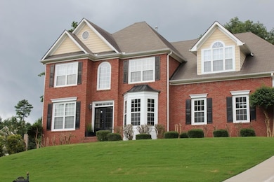Colonial inspired home with brick siding and a front yard