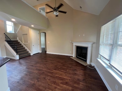 Unfurnished living room with a ceiling fan, a fire