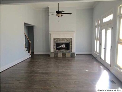 Family Room w hardwood floors anchored by fireplac