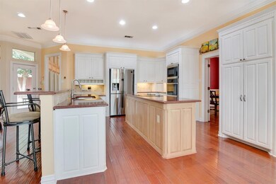 Texas-Sized Island Kitchen Features Abundant Cabinets with Custom Mouldings, Granite Countertops, Tile Backsplash, Pendant and Recessed Lighting and Upgraded Stainless Appliances Including Double Ovens.