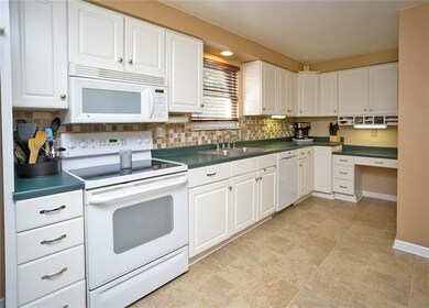 The ceramic tile backsplash adorns this all white 